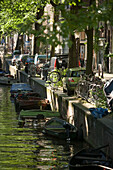 Leisure Boats, Oude Schans, A small leisure boat passing house boats on Oude Schans, Amsterdam, Holland, Netherlands