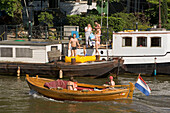 Leisure Boats, Oude Schans, A small leisure boat passing house boats on Oude Schans, Amsterdam, Holland, Netherlands