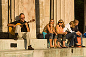 People sitting on stairs of Theseus Temple at Volksgarten, Vienna, Austria