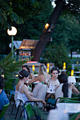 Young women sitting in a restaurant in the Volksgarten at evening, Vienna, Austria