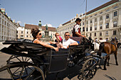 Fiaker passing Alte Hofburg during a city tour, Vienna, Austria