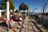 People sitting in deck chairs at harbour, People sitting in deck chairs at sandy open-air area of restaurant at Oevelgönne, Hamburg, Germany