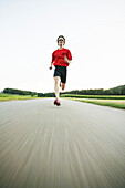 Young man jogging on country road