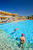 People swimming in open-air pool of Szechenyi-Baths, Pest, Budapest, Hungary