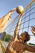 Young people playing beach volleyball