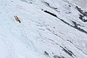 Male ice climber ascending ice, British Columbia, Canada