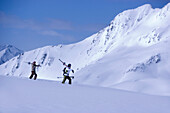 Zwei Skifahrer laufen auf schneebedecktem Berg, Kühtai, Tirol, Österreich