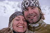 Young couple snuggling together, faces full of snow, Kuehtai, Tyrol, Austria