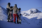 Junges Paar mit Snowboards genießt das Bergpanorama, Kühtai, Tirol, Österreich
