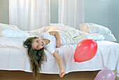 Mädchen spielt mit Luftballons