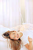 Little girl lying on bed, portrait