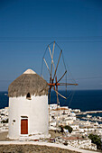 View from hill with famous traditional windmill over the town to the sea with ships, Mykonos-Town, Mykonos, Greece
