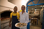 Cook and waiter of the greek fish restaurant Kounelas, Mykonos-Town, Mykonos, Greece