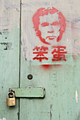 Bush graffiti,Graffiti portrait of George W Bush, US president, anti-Bush, anti-american, antiamerikanisch, chinesische Schriftzeichen, chinese characters, spray art, door with padlock, Tür mit Vorhängeschloß, aus: "Mythos Shanghai", Shanghai, Sachbuch, B