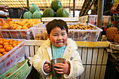 Kind, kid, child,young boy at the market stand of his parents, Junge am Marktstand, Markthalle, market hall, fruit and vegetables, Gemüse, Frucht, Kinder, Kleiner Kaiser, Little Emperor, Einzelkind, only child, aus: "Mythos Shanghai", Shanghai, Sachbildba