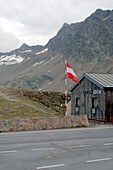 Wooden house with flag at mountain pass Timmelsjoch, Tyrol, Austria