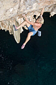 Boulderer on rock near Puerto Christo, Majorca, Spain