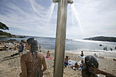 Costa Brava,Badegäste, Dusche am Strand von  Calella, Costa Brava, Katalonien Spanien