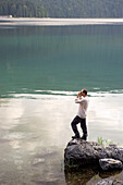 Man looking with binocular over Lake, Eibsee, Bavaria Germany
