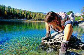 Woman refreshing at a mountain lake, Valley of the seven lakes, Triglav Nationalpark, Julian Alps, Slovenia, Alps.