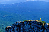 Frau wandert über einen ausgetzten Berggrat. Debela Pec, Hintergrund: Wald von Pokljuka, Triglav Nationalpark, Julische Alpen, Slowenien, Alpen,.