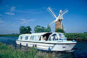 Leisure boats on canal next to How Hill windpump, Norfolk Broads, England