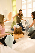 Teenage girls (14-16) having pillow fight