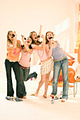 Teenage girls (14-16) singing into hair brushes