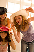 Teenage girls (14-16) posing, wearing hats