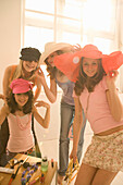Teenage girls (14-16) posing, wearing hats