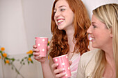 Zwei Freundinnen trinken zusammen eine Tasse Tee