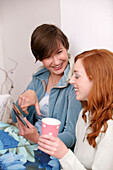 Two young women looking at photographs and smiling