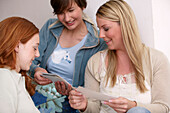 Young women on sofa looking at photographs