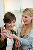 Young women testing perfume in shop