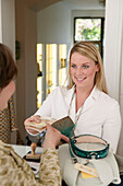 Young woman paying cashier in shop