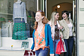 Young women walking out of shop with shopping bags