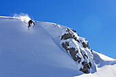 Ein Mann, ein Skifahrer, ein Freerider springt in einen steilen Schneehang. Lech, Zürs, Arlberg, Österreich, Alpen, Europa, MR