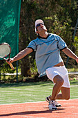 Male tennis player celebrating on court, Apulia, Italy