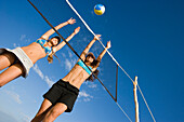 Two young woman playing beach volleyball, Apulia, Italy