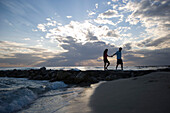 Couple walking on beach, evening mood, Apulia, Italy