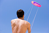 Young man holding kite string, Apulia, Italy