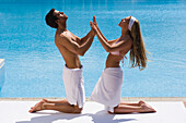 Young couple pressing hands together on poolside, Apulia, Italy