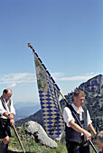 Flag carrier with bavarian flag, procession, Schachen, Bavaria, Germany