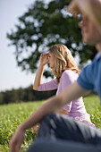 Man and woman sitting on meadow and watching out