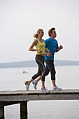 Man and woman running on jetty