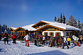 Skiers sitting in front of mountain restaurant (Birkhahnalm), Flachau, Salzburger Land, Austria
