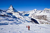 Skiers on mountain slope, Matterhorn in background, Zermatt, Valais, Switzerland