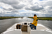 Houseboat Skipper Navigating Janesloot River,Crown Blue Line Royal Classic, Frisian Lake District, Netherlands