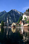 Hallstatt with evangelist and catholic church and reflections in lake Hallstätter See, Salzkammergut, Upper Austria, Austria