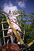 Young woman at playground, arms raised, low angle view